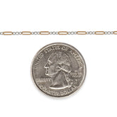 Two-tone chain next to a quarter on a white background